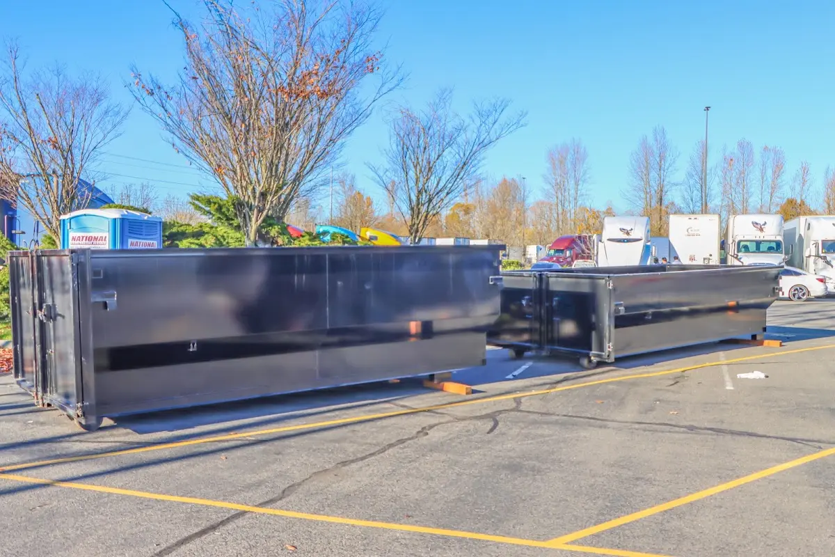 Professional dumpster rental service with roll-off container on residential driveway in Brookings